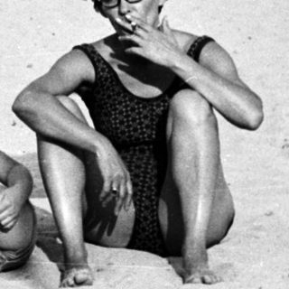 Black and white photo of people relaxing on a beach.
