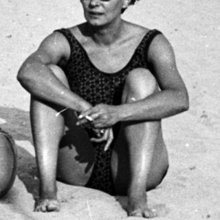 Black and white photo of people relaxing on a beach.