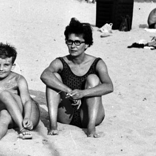 Black and white photo of people relaxing on a beach.