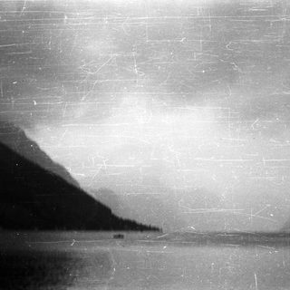 Monochromatic landscape with a mountain reflected in water.