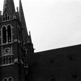 Black and white image of a church tower with a spire.