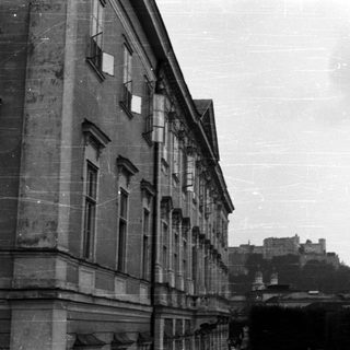 Building facade with castle visible in the distance.