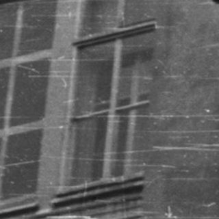 Black and white photo depicts a stone architectural facade.