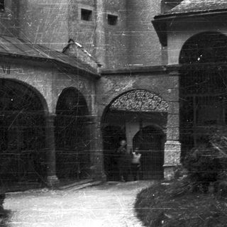 Arched passageway with a figure and aged stonework.