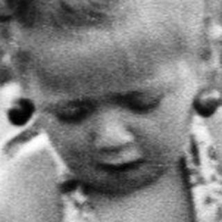 Here's a brief summary of the image: Child plays in a shallow pool outdoors.