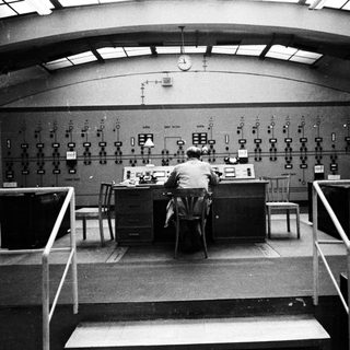 Man working at control panel in a monitoring room.