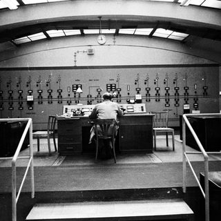 Man working at control panel in a monitoring room.