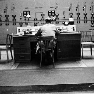Operator monitors equipment in a control room.