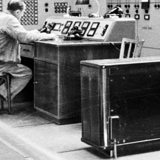 Control room with operators monitoring complex electrical systems.