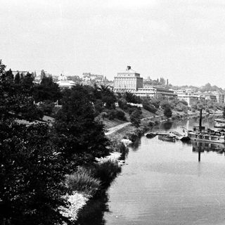 River scene with dredging equipment and building in background.