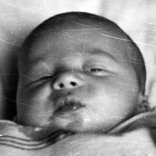 Sleeping baby in a crib, vintage black and white photo.