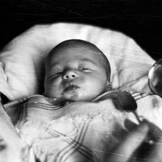 Sleeping baby in a crib, vintage black and white photo.