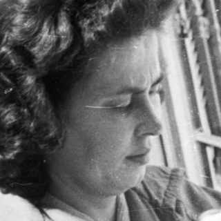 Woman holding a baby on a porch.