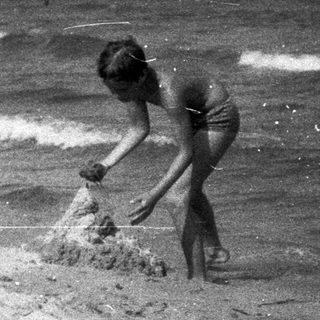 Two children building a sandcastle on a beach.