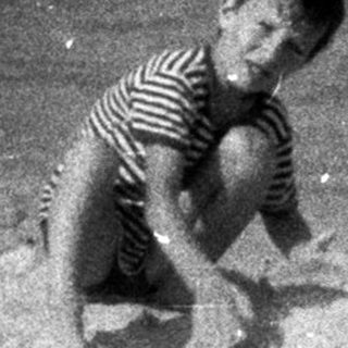Two children building a sandcastle on a beach.