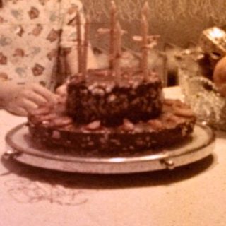 Girl seated at a table with a birthday cake.