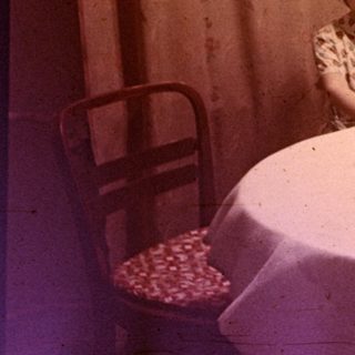 Girl seated at a table with a birthday cake.