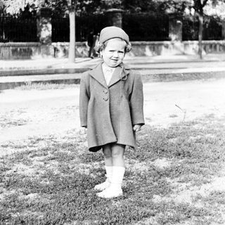 Black and white image of a young girl in a coat.