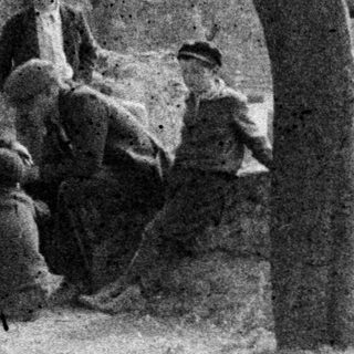 Group of boys gathered outdoors, seemingly playing or resting.