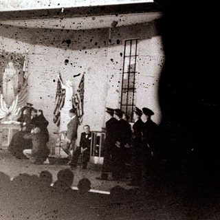 Group of people on stage with flags and a ladder.