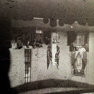 Group gathers in a room with flags and a portrait.