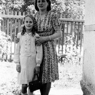 Black and white photo of a girl and woman standing outside.