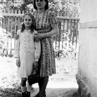 Black and white photo of a girl and woman standing outside.