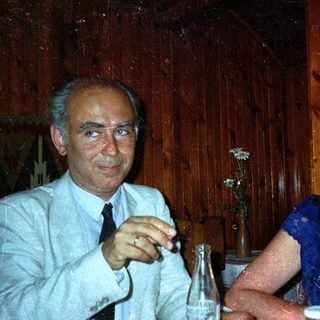 Couple seated at a table in a wood-paneled room.