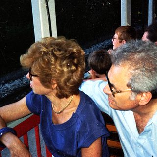 People seated outdoors, appearing to be watching something.