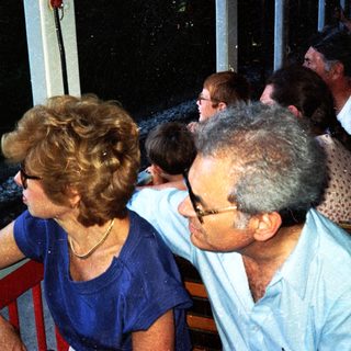 People seated outdoors, appearing to be watching something.