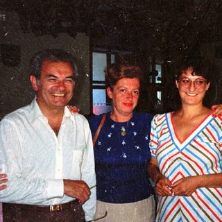 Three people are posing for a photograph indoors.