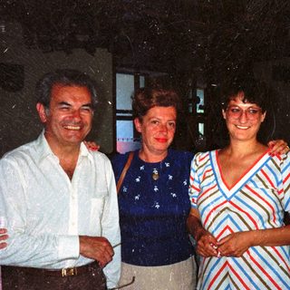 Three people are posing for a photograph indoors.