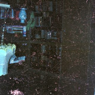 Dark, grainy image of a room with a chair.