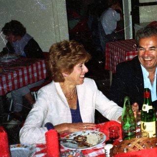 Three people dine together at a restaurant table.