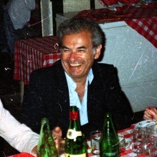 Three people dine together at a restaurant table.