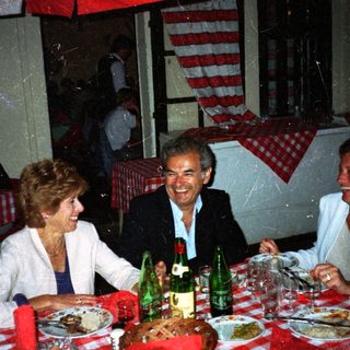 Three people dine together at a restaurant table.