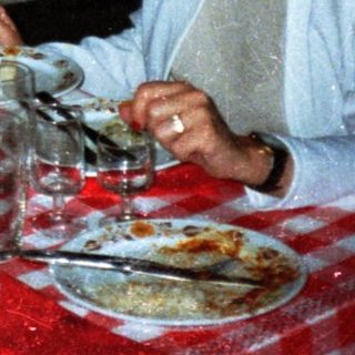 Three people dine together at a restaurant table.
