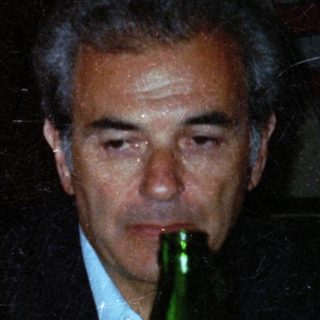 Couple seated at table with drinks, looking concerned.