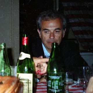 Couple seated at table with drinks, looking concerned.