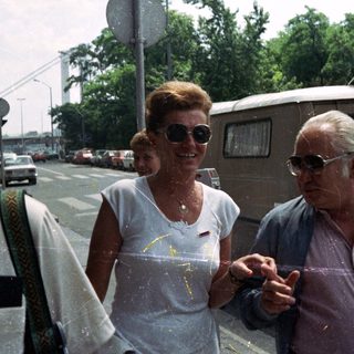 Couple walking outdoors near a street and van.
