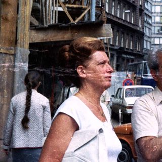 Couple walks down a street with building construction nearby.