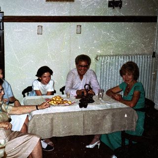 Four people seated around a table in a dining room.