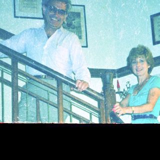 Couple posing on stairs inside a home.