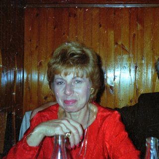 Couple seated together, smiling, in a wood-paneled setting.