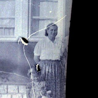 Woman stands near a window in an old building.