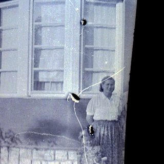 Woman stands near a window in an old building.