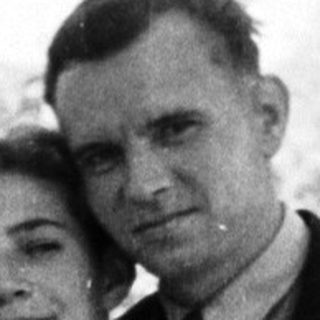 Black and white photo of a couple seated outdoors.