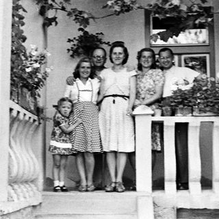Family portrait on a porch, circa mid-20th century.