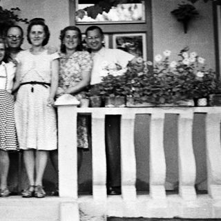 Family portrait on a porch, circa mid-20th century.