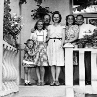 Family portrait on a porch, circa mid-20th century.